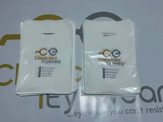 Stacks of printed white carrier bags for Claracasa Eyewear, one of the real client jobs shown in the LaGraphico work gallery